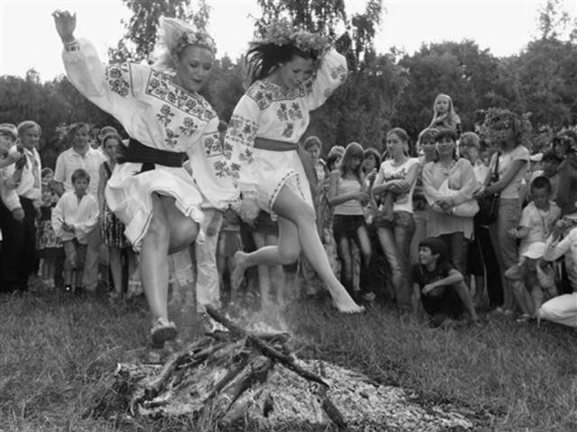 Two Ukrainian women leaping over a fire