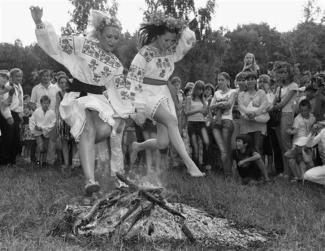 Two Ukrainian women leaping over a fire